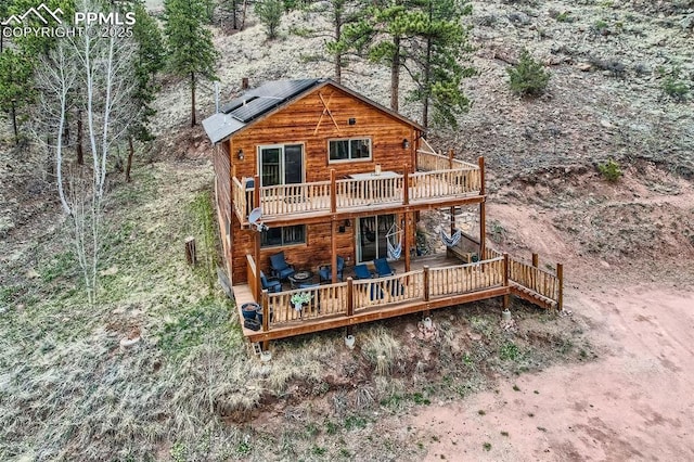 1978 High Chateau Rd, Florissant, CO 80816 - back of property featuring a wooden deck and roof mounted solar panels