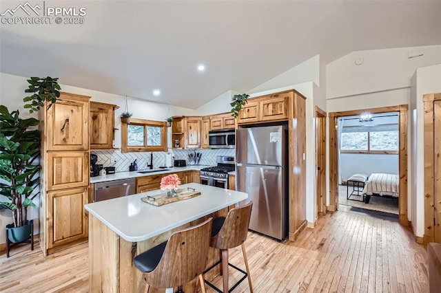 1978 High Chateau Rd, Florissant, CO 80816 - kitchen featuring stainless steel appliances, a sink, vaulted ceiling, light wood-style flooring, and backsplash