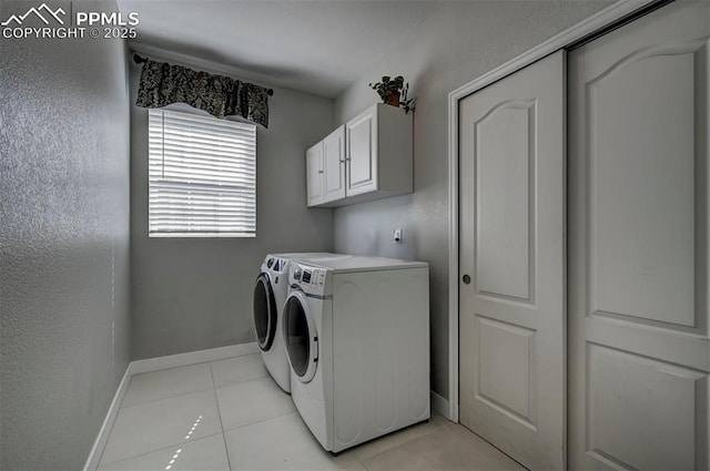 laundry room featuring separate washer and dryer, light tile patterned flooring, baseboards, and cabinet space