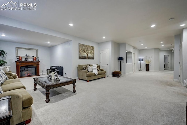 carpeted living area with recessed lighting, a glass covered fireplace, and baseboards
