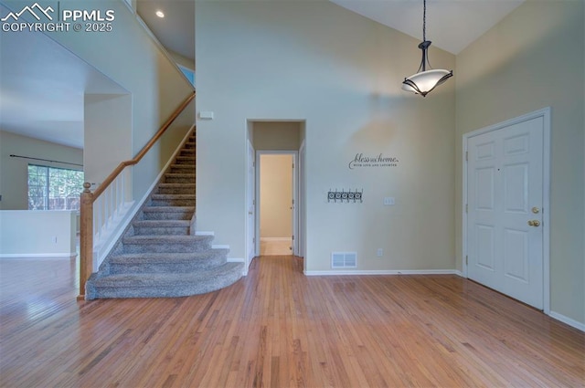 6726 Annanhill Pl, Colorado Springs, CO 80922 - foyer entrance featuring a towering ceiling, wood finished floors, stairway, and baseboards