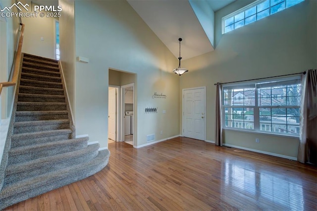 6726 Annanhill Pl, Colorado Springs, CO 80922 - foyer entrance with wood finished floors, stairs, high vaulted ceiling, and baseboards