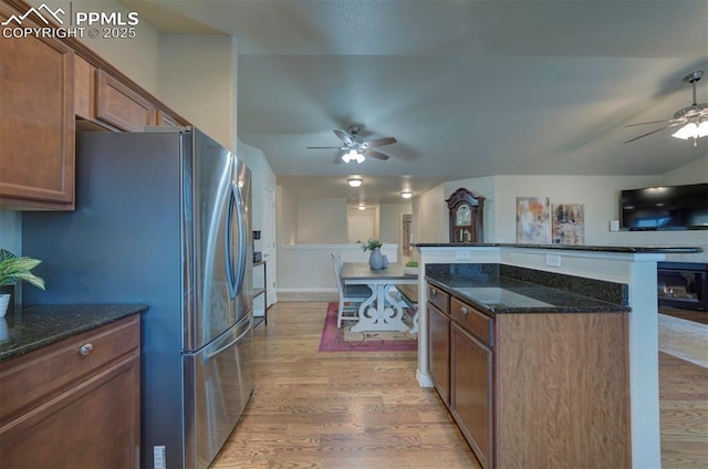 6752 Red Cardinal Loop, Colorado Springs, CO 80908 - kitchen with ceiling fan, light wood-style flooring, dark stone counters, and freestanding refrigerator