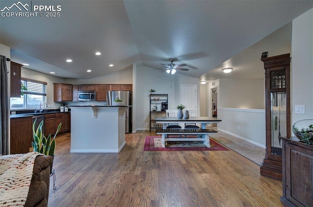 6752 Red Cardinal Loop, Colorado Springs, CO 80908 - kitchen with appliances with stainless steel finishes, dark countertops, vaulted ceiling, a center island, and ceiling fan
