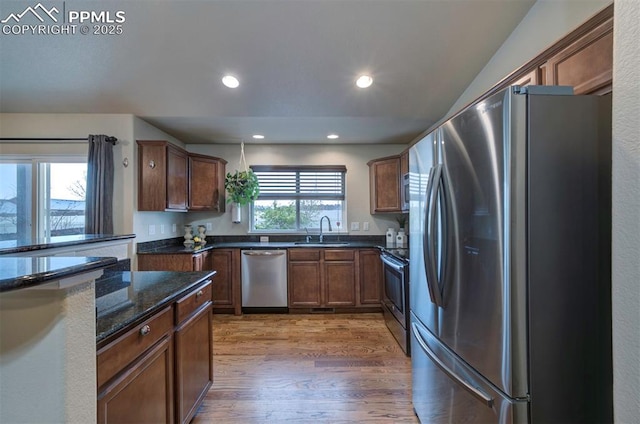 6752 Red Cardinal Loop, Colorado Springs, CO 80908 - kitchen with appliances with stainless steel finishes, a sink, light wood finished floors, dark stone countertops, and recessed lighting