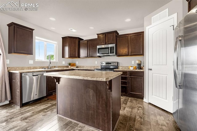 11081 Buckhead Pl, Fountain, CO 80817 - kitchen with appliances with stainless steel finishes, dark wood-type flooring, dark brown cabinets, light countertops, and a kitchen island