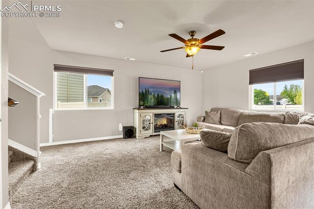 11081 Buckhead Pl, Fountain, CO 80817 - carpeted living room with ceiling fan, healthy amount of natural light, baseboards, and a glass covered fireplace