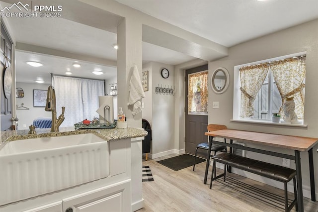 dining area with light wood-type flooring and baseboards