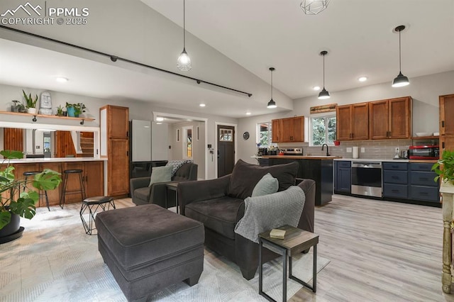 living area featuring vaulted ceiling, recessed lighting, and light wood-style floors