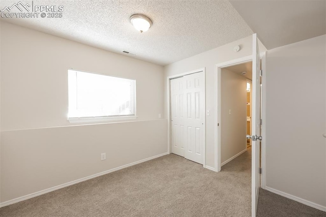 5805 Dutchess Dr, Colorado Springs, CO 80923 - unfurnished bedroom with carpet floors, a closet, a textured ceiling, and baseboards