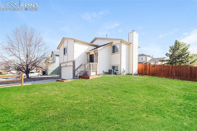 5805 Dutchess Dr, Colorado Springs, CO 80923 - back of property featuring asphalt driveway, a chimney, a garage, and central air condition unit
