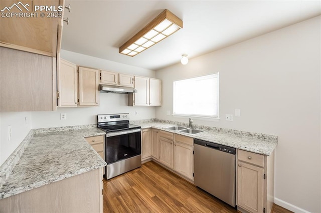 5805 Dutchess Dr, Colorado Springs, CO 80923 - kitchen featuring stainless steel appliances, a sink, wood finished floors, light brown cabinetry, and under cabinet range hood
