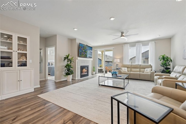 5932 Torrisdale Vw, Colorado Springs, CO 80927 - living area featuring wood finished floors, ceiling fan, a glass covered fireplace, recessed lighting, and baseboards