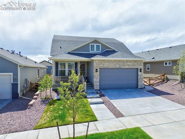 5932 Torrisdale Vw, Colorado Springs, CO 80927 - view of front facade featuring a garage, a porch, stone siding, concrete driveway, and roof with shingles