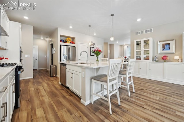 5932 Torrisdale Vw, Colorado Springs, CO 80927 - kitchen with appliances with stainless steel finishes, a sink, white cabinetry, a kitchen bar, and light countertops