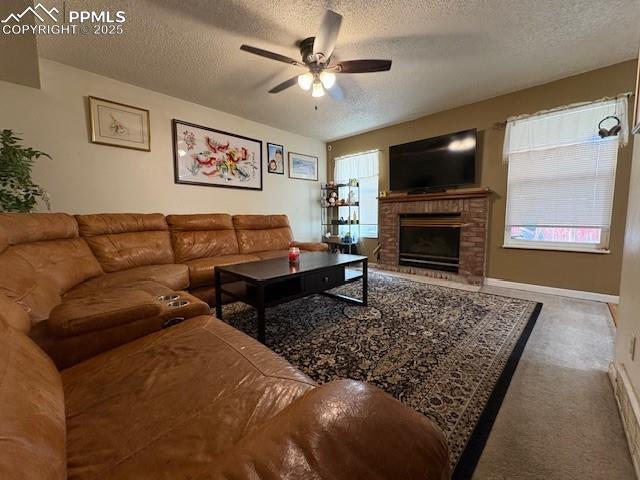 905 Hubbell Dr, Colorado Springs, CO 80911 - living room featuring a textured ceiling, carpet flooring, ceiling fan, a fireplace, and baseboards