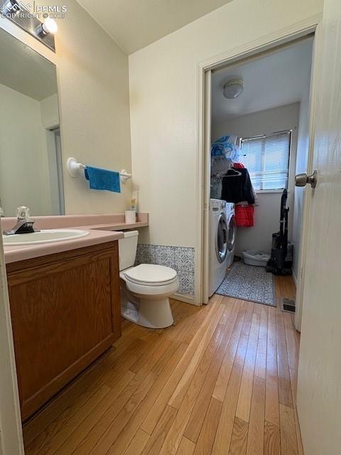 905 Hubbell Dr, Colorado Springs, CO 80911 - bathroom with washing machine and clothes dryer, hardwood / wood-style floors, toilet, and vanity