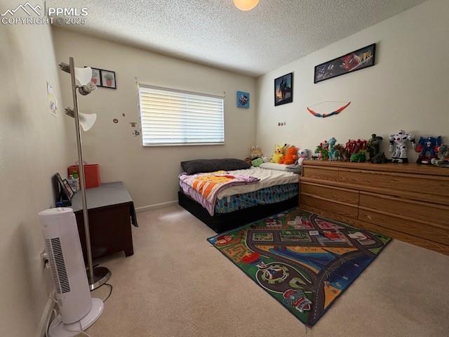 905 Hubbell Dr, Colorado Springs, CO 80911 - bedroom featuring light colored carpet and a textured ceiling