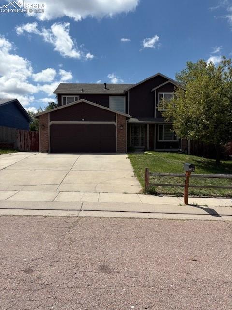 905 Hubbell Dr, Colorado Springs, CO 80911 - traditional-style home with an attached garage, driveway, and brick siding
