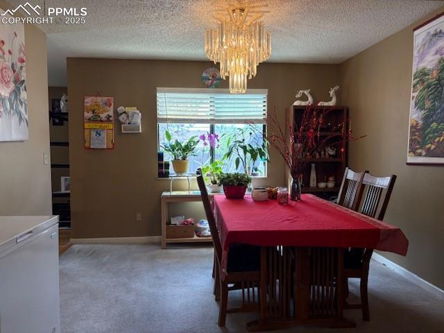 905 Hubbell Dr, Colorado Springs, CO 80911 - dining room featuring carpet floors, a chandelier, a textured ceiling, and baseboards