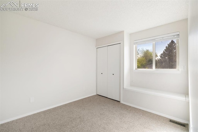 956 Azure Cir, Colorado Springs, CO 80910 - unfurnished bedroom featuring carpet flooring, a closet, a textured ceiling, and baseboards