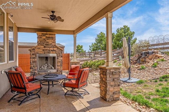 10282 Mt Lincoln Dr, Peyton, CO 80831 - view of patio featuring an outdoor stone fireplace, fence, and ceiling fan