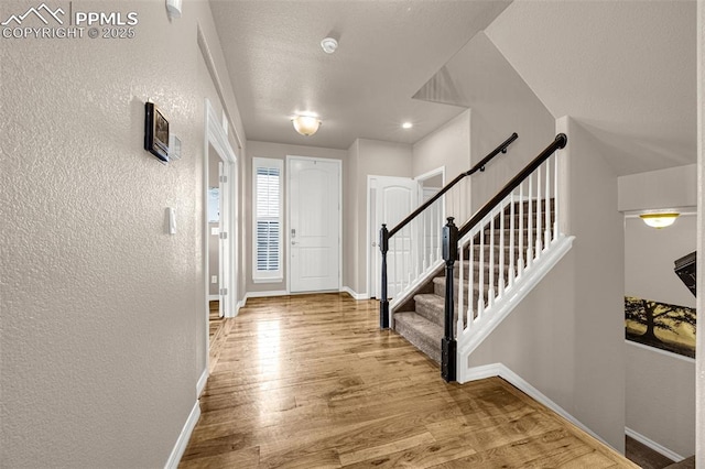 10282 Mt Lincoln Dr, Peyton, CO 80831 - entrance foyer featuring a textured wall, baseboards, wood finished floors, and stairway