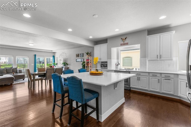 8674 Tranquil Knoll Ln, Colorado Springs, CO 80927 - kitchen with appliances with stainless steel finishes, backsplash, open floor plan, a kitchen island, and light countertops