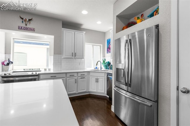8674 Tranquil Knoll Ln, Colorado Springs, CO 80927 - kitchen featuring stainless steel appliances, light countertops, dark wood-style floors, a sink, and decorative backsplash