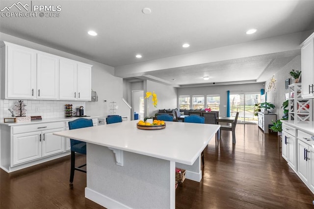 8674 Tranquil Knoll Ln, Colorado Springs, CO 80927 - kitchen featuring open floor plan, a breakfast bar, light countertops, a kitchen island, and dark wood finished floors