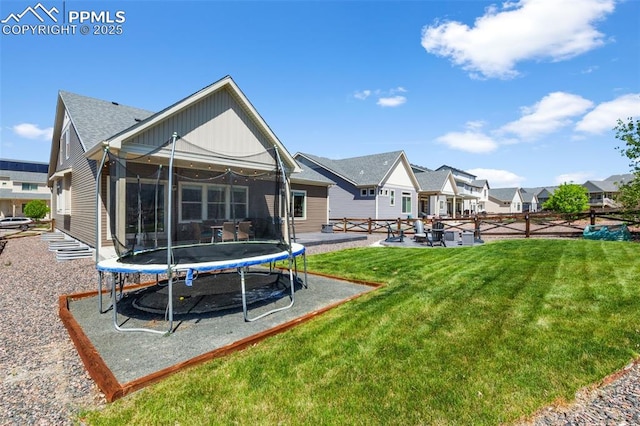 8674 Tranquil Knoll Ln, Colorado Springs, CO 80927 - back of property with a trampoline, a yard, a residential view, and a patio area
