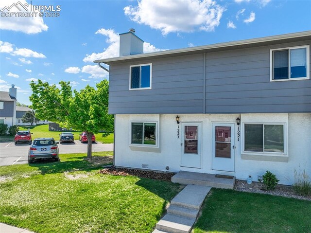 1223 Soaring Eagle Dr, Colorado Springs, CO 80915 - view of front of house with a front lawn and a chimney