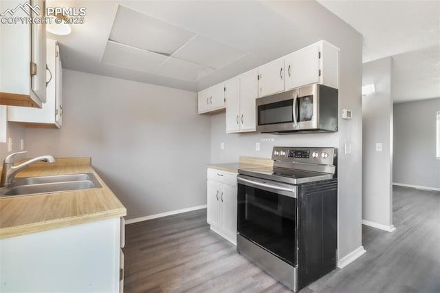 1223 Soaring Eagle Dr, Colorado Springs, CO 80915 - kitchen featuring appliances with stainless steel finishes, a sink, wood finished floors, and white cabinetry