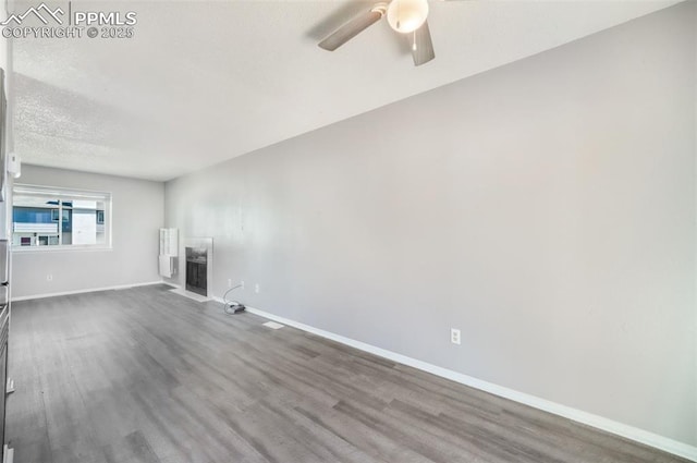 1223 Soaring Eagle Dr, Colorado Springs, CO 80915 - unfurnished living room with a ceiling fan, wood finished floors, baseboards, and a textured ceiling