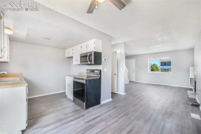 1223 Soaring Eagle Dr, Colorado Springs, CO 80915 - kitchen featuring stainless steel appliances, a sink, light wood-style flooring, baseboards, and white cabinetry