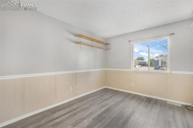 1223 Soaring Eagle Dr, Colorado Springs, CO 80915 - unfurnished room with wood finished floors, a textured ceiling, and baseboards