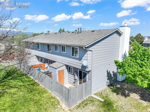 1223 Soaring Eagle Dr, Colorado Springs, CO 80915 - back of house with a chimney and a shingled roof