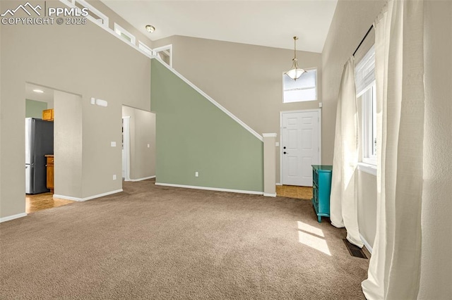 8290 Meadowcrest Dr, Fountain, CO 80817 - foyer featuring carpet floors, high vaulted ceiling, and baseboards
