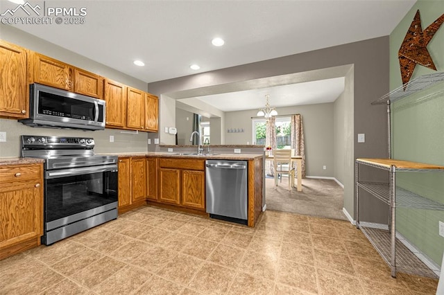 8290 Meadowcrest Dr, Fountain, CO 80817 - kitchen featuring appliances with stainless steel finishes, a sink, a chandelier, a peninsula, and brown cabinets