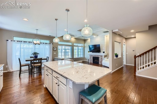 7225 Horizon Wood Ln, Colorado Springs, CO 80927 - kitchen with dark wood finished floors, a brick fireplace, white cabinets, baseboards, and recessed lighting