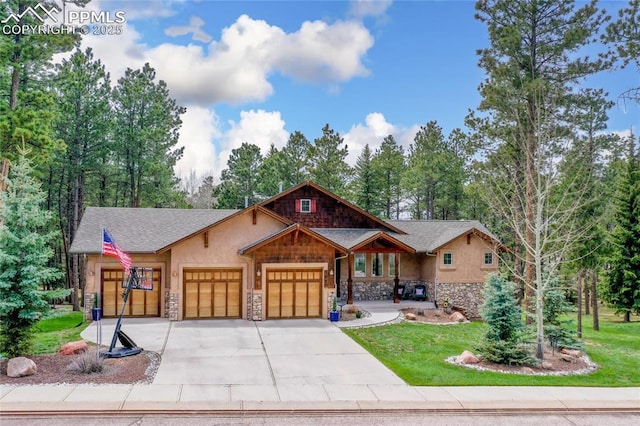 1230 Cottontail Trl, Woodland Park, CO 80863 - view of front of house with stone siding, a garage, concrete driveway, and stucco siding