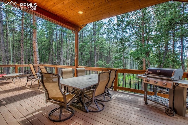 1230 Cottontail Trl, Woodland Park, CO 80863 - wooden deck with outdoor dining space, grilling area, and a view of trees