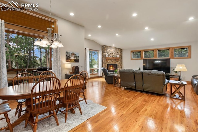 1230 Cottontail Trl, Woodland Park, CO 80863 - dining area featuring a stone fireplace, light wood-style flooring, recessed lighting, vaulted ceiling, and a chandelier