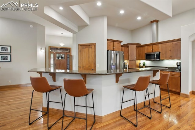 1230 Cottontail Trl, Woodland Park, CO 80863 - kitchen with appliances with stainless steel finishes, a breakfast bar, baseboards, light wood-style floors, and recessed lighting