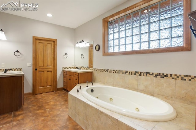 1230 Cottontail Trl, Woodland Park, CO 80863 - full bathroom with two vanities, a whirlpool tub, and baseboards