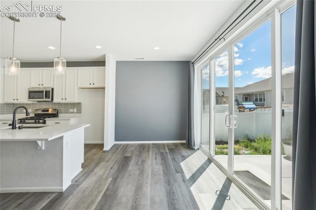 1145 Ibex Dr, Severance, CO 80550 - kitchen with stainless steel appliances, plenty of natural light, a sink, white cabinetry, and recessed lighting