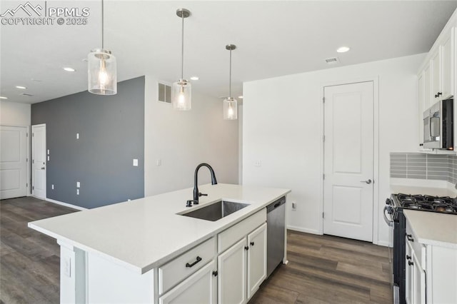 1145 Ibex Dr, Severance, CO 80550 - kitchen with stainless steel appliances, a sink, dark wood-type flooring, white cabinets, and recessed lighting