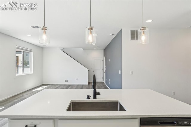 1145 Ibex Dr, Severance, CO 80550 - kitchen with a sink, wood finished floors, dishwasher, light countertops, and decorative light fixtures
