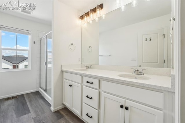 1145 Ibex Dr, Severance, CO 80550 - full bath featuring wood finished floors, a stall shower, double vanity, and baseboards