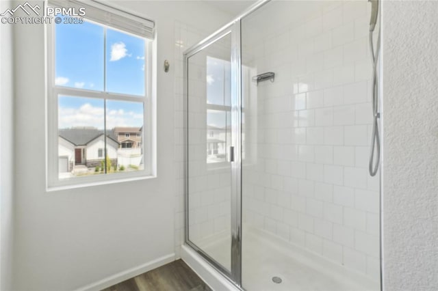 1145 Ibex Dr, Severance, CO 80550 - full bathroom featuring a stall shower, wood finished floors, and baseboards